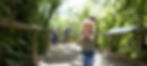 Child smiling while exploring the walk-through aviary at Otorohanga Kiwi House, surrounded by native New Zealand birds