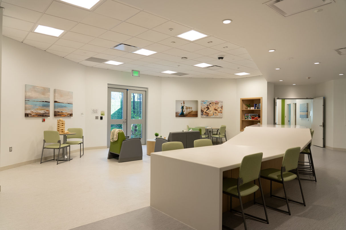 large room with chairs, couches, and art on the wall.