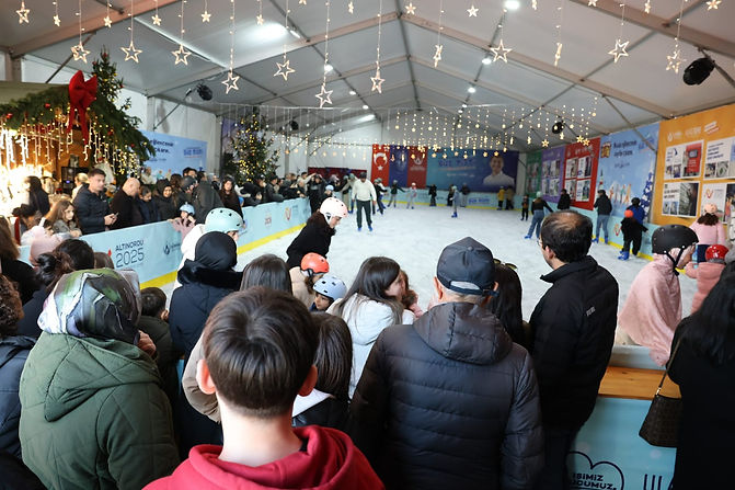 Families and children skating and watching at the tented Christmas market ice rink