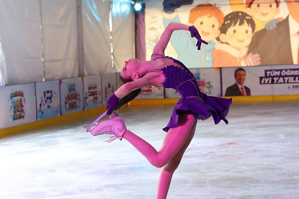 Professional figure skater performing a spiral pose on the tented rink ice
