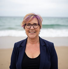 whispy hair, black top blue blazer blurry beach.jpeg