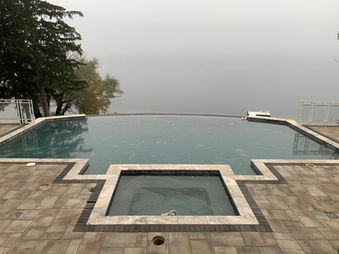 Lakeside infinity pool with brick pavers