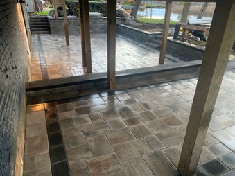 Lakeside multi-level brick paver patio under backyard deck