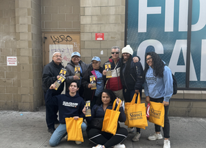 Shanel and her amazing volunteers posting for a photo with tote bags and flyers in hand 