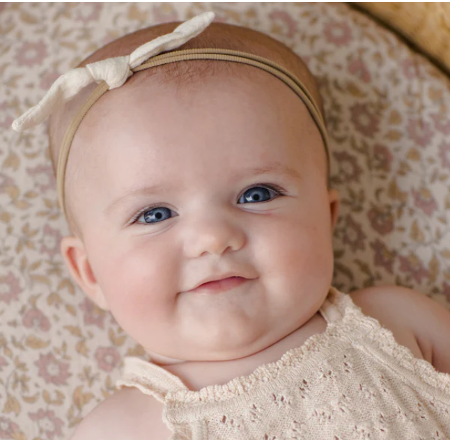 baby with cream bow headband