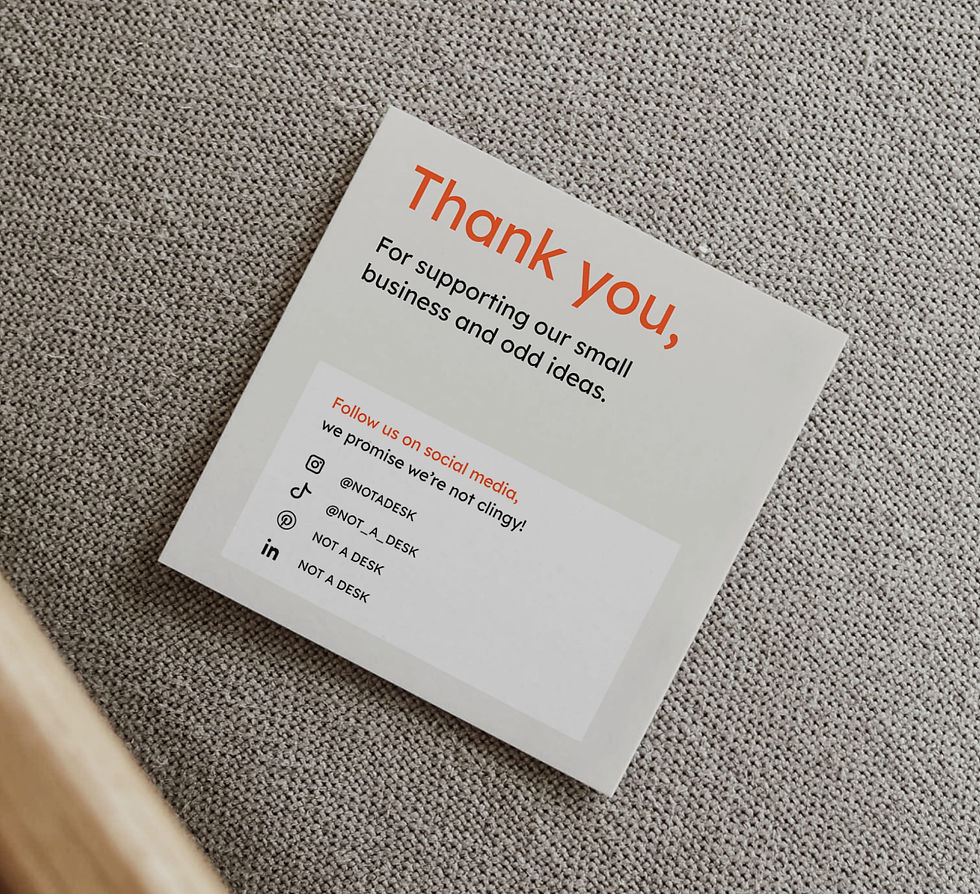 Thank you card for NOT A DESK packaging, featuring minimalist graphic design and brand messaging, placed on textured fabric surface as part of sustainable workspace branding.