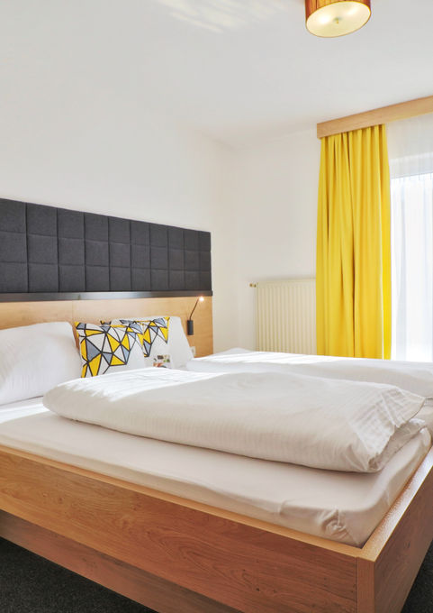 Bright and friendly standard double room (20m²) with carpeted floor and access to the balcony.