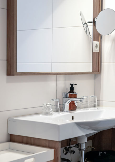 Modernes, frisch renoviertes Badezimmer im Alpin-Studio mit begehbarer Dusche und frischen Handtüchern.