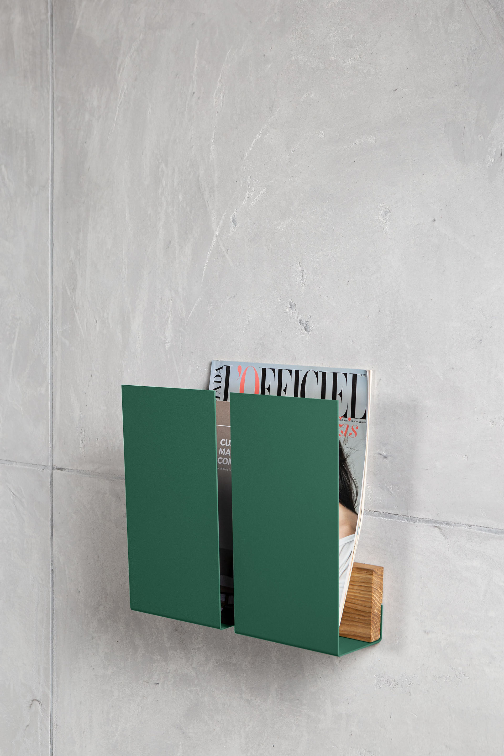 Magazine Newspaper Holder in Green color mounted on the wall with L'officiel magazine in it