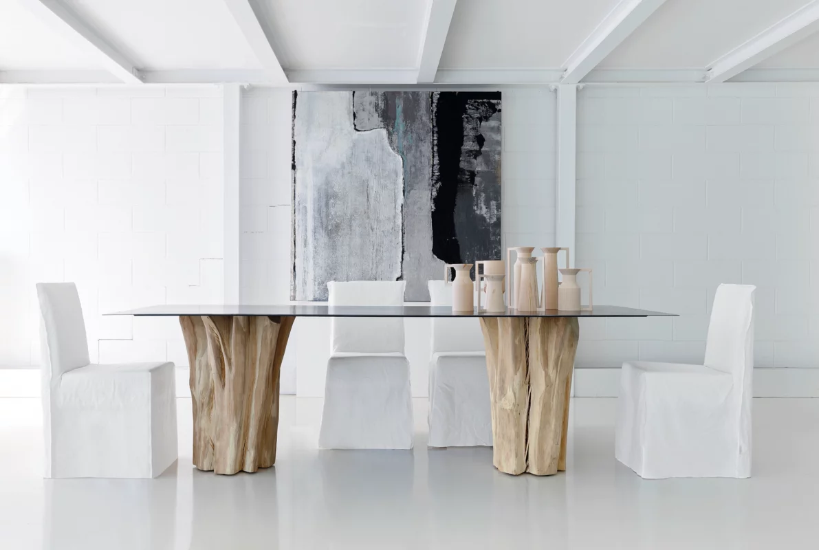 Brick 33 table by Paola Navone with 4 white chairs around it and decor items atop