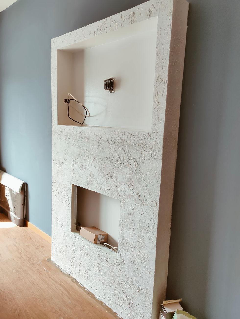 Custom fireplace feature during construction, transforming an existing structure in an apartment interior design project in Portimão.