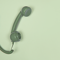 Green vintage telephone handset on a soft green background, symbolising one-on-one author consultations.