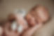 sleeping newborn holding teddybear