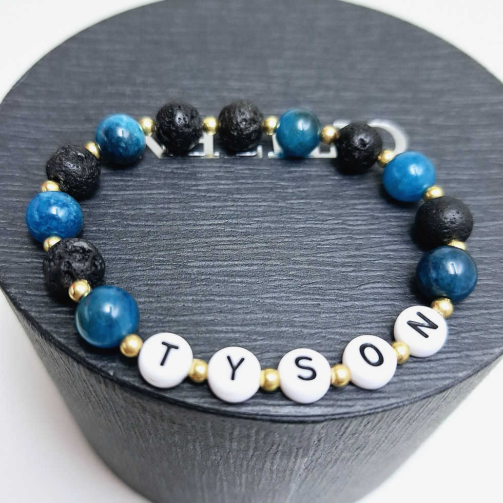 Indexkép: Blue apatite gemstone and black lava stones with custom name beads and golden spacer beads top view
