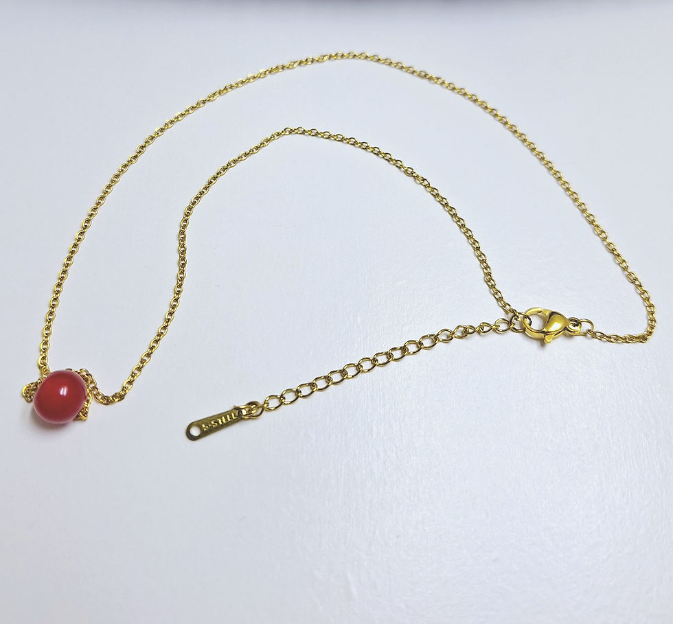 Miniatura: an elegant golden necklace with a red glass bead