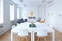 bureau dans un bâtiment parisien contenant des tables, chaises et un canapé