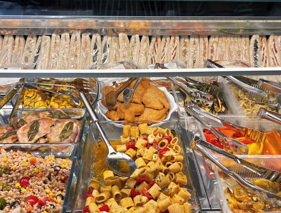 Vetrina tavola calda del Paris Bar con panini, primi piatti, contorni e preparazioni gastronomiche.