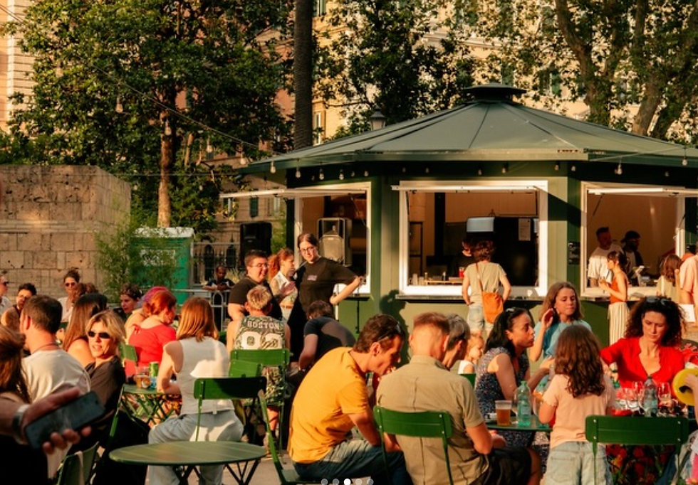 Tavoli all'aperto tra il verde durante un evento con dj set del Vinificio Roma