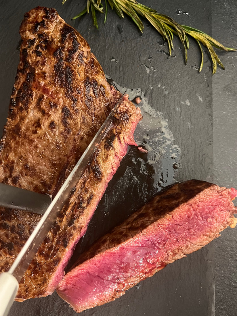 Tagliata di manzo posizionata su un tagliere in pietra