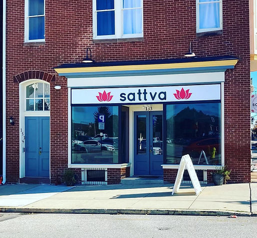 a small yoga studio in downtown york PA with a sign out front