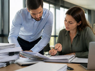 two professionals conducting an ERP audit, reviewing submitted documents