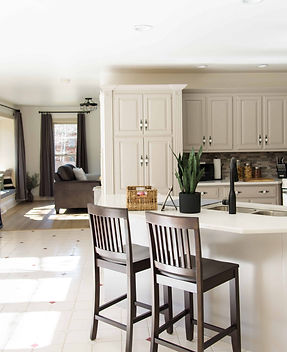 Fully set up airbnb kitchen with barstools, plants, and coffee bar