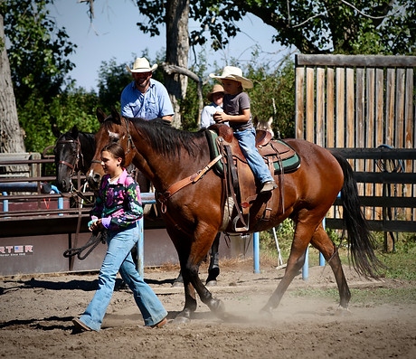 leading young cowboy on his horse