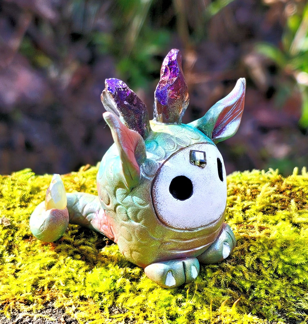 Nooshi is a compact, roundish Tiny Beastie with rough, iridescent rock-crystal horns.