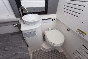 Clean interior bathroom with toilet and sink inside the Sea Fox 36 boat rental.