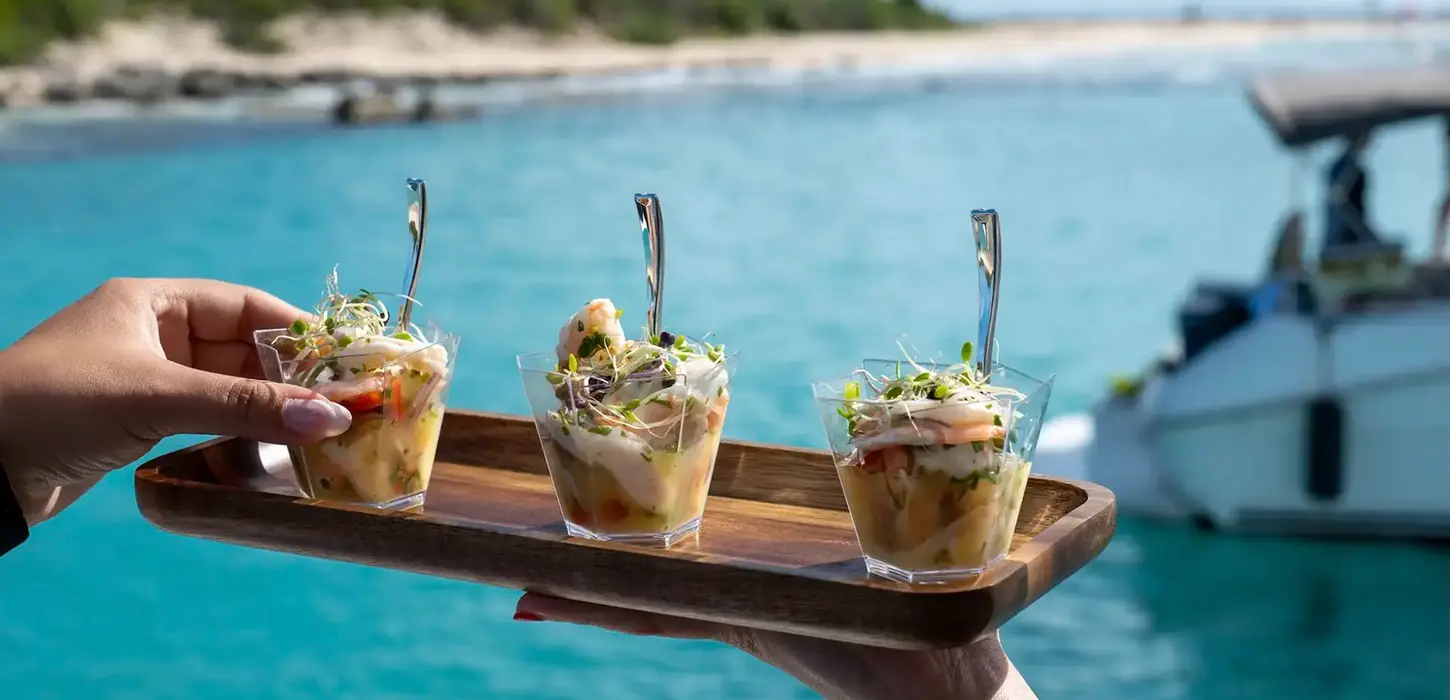 Gourmet appetizers served on a wooden tray during a private boat tour in Puerto Rico.