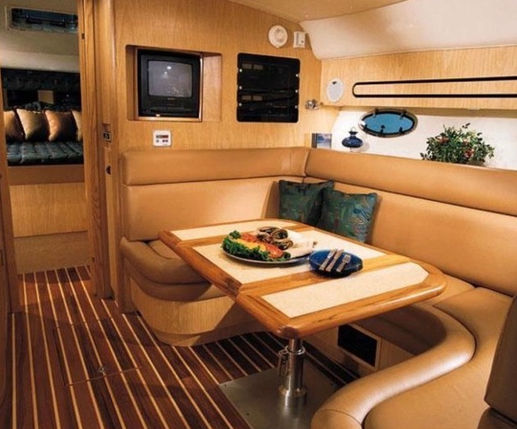 Wood-finished interior saloon and dining table inside the Palomino Tiara 40 yacht charter.