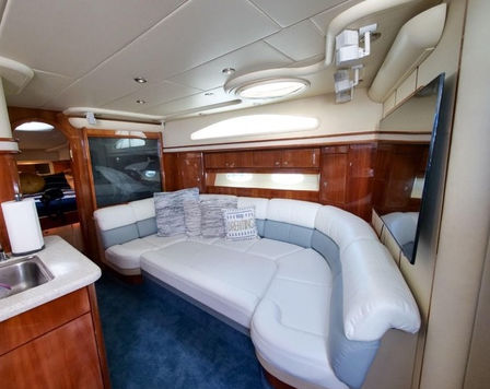 Lower deck lounge area with sofa inside the Just to Splash Neptuno 60 private boat charter.