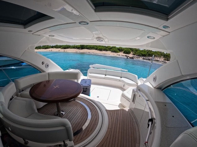 Outdoor dining table and seating on the aft deck of the Sea Ray 55 private yacht.