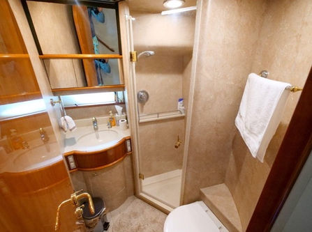 Wood-finished interior bathroom and shower inside the Just to Splash Neptuno 60 yacht.