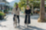 A man and woman walk bikes on a sunny street, smiling at each other. Blog about reconnection in relationships.