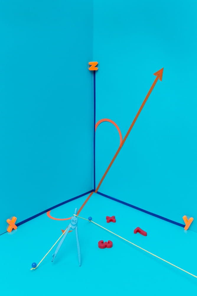 Compass on blue backdrop with orange 3D letters X, Y, Z marking axes. Blue and orange arrows form 3D grid lines intersecting at angles.