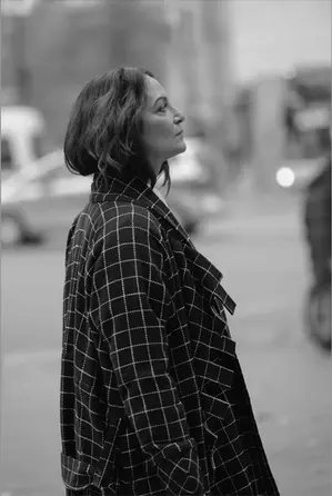 Schwarz-weiß Editorial-Aufnahme einer Frau im karierten Mantel auf der Straße – aus dem Editorial Portfolio von Stil-ch, stilvoll inszeniert mit urbanem Charakter.