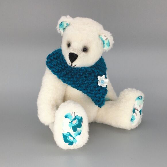 White memory bear with teal scarf and patterned paws