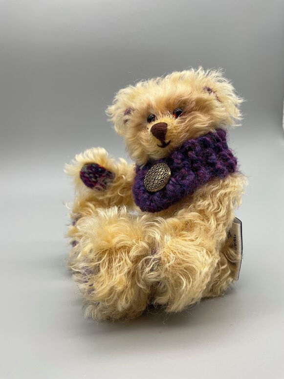 Fluffy memory bear with purple scarf and button