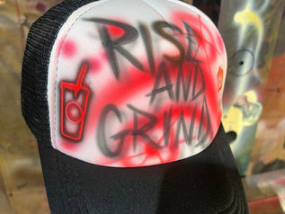 Black trucker hat with Rise and Grind lettering and a red coffee cup design for 7 Brew in Nashville