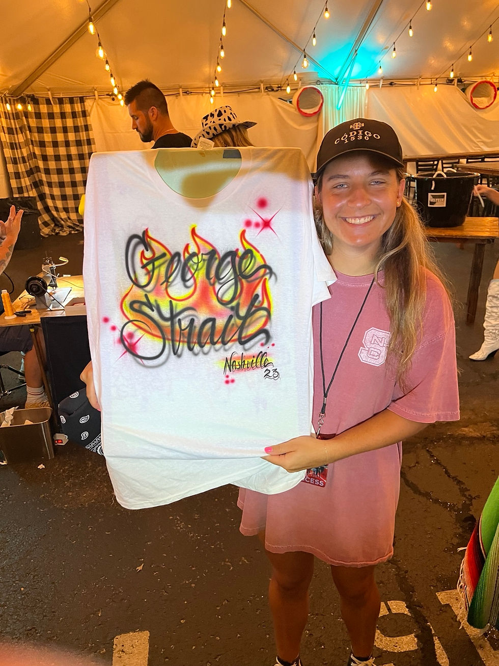 Backstage guest holding a personalized George Strait Nashville airbrushed shirt