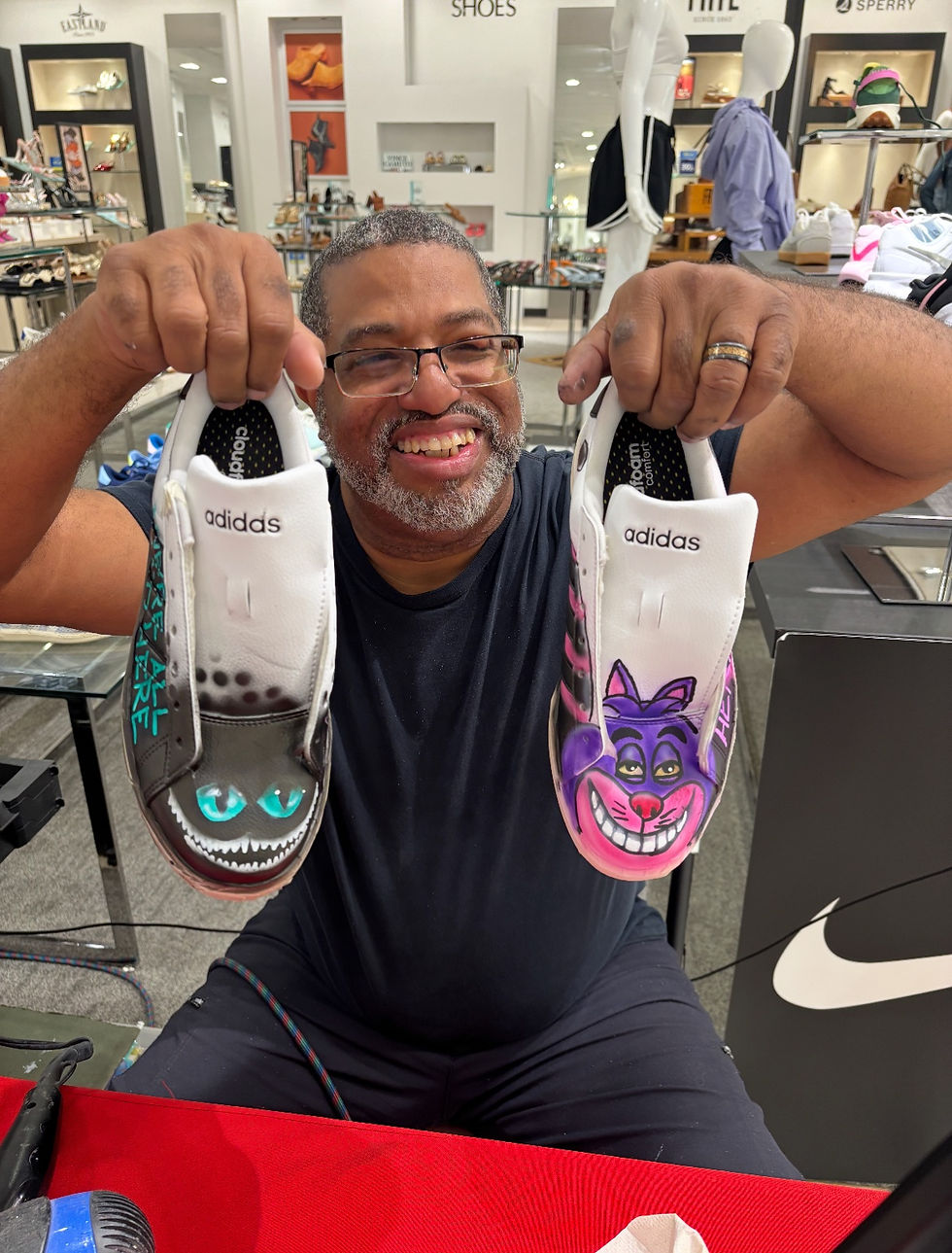 Artist displaying customized sneakers at a Belk event