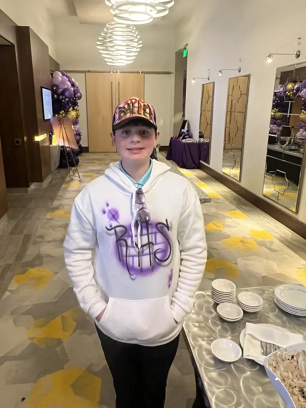Guest wearing a purple airbrushed hoodie and colorful trucker hat at an event in Portland, Oregon