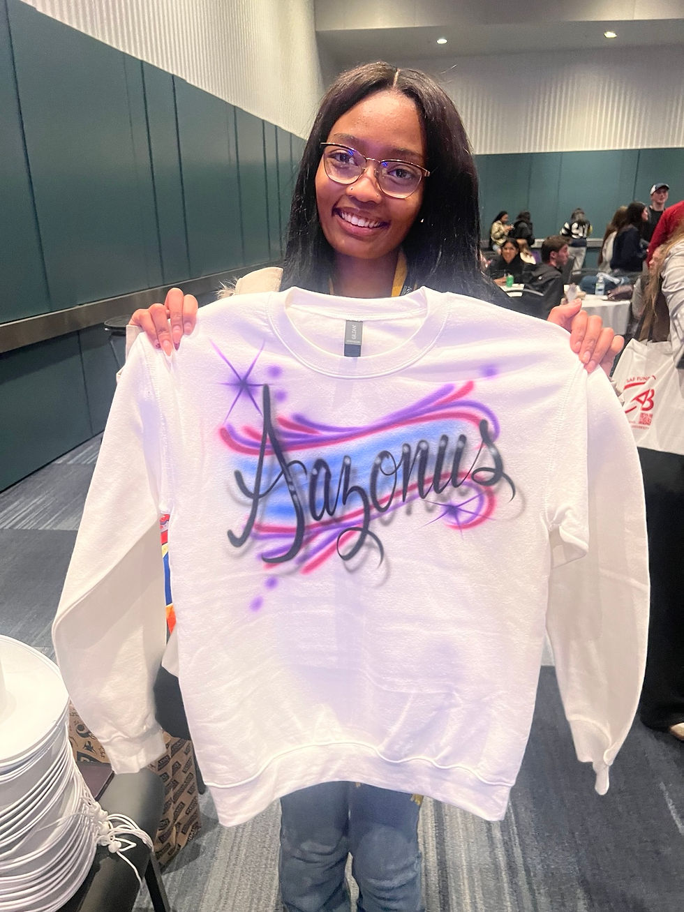 Student holding a personalized purple sweatshirt