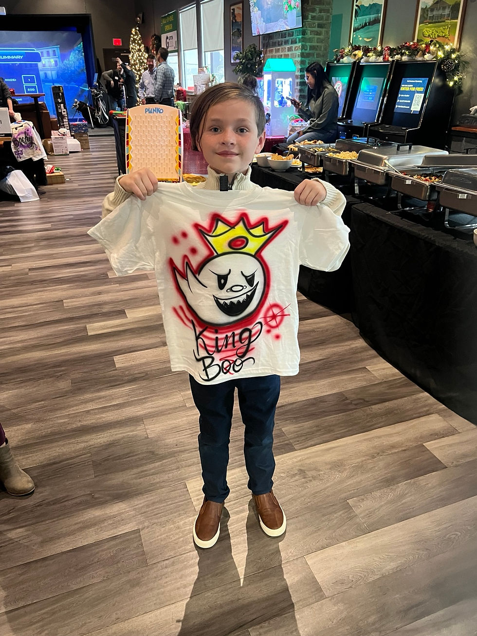 Young guest showing a personalized crown-design airbrushed shirt at a corporate activation in Wake Forest, North Carolina