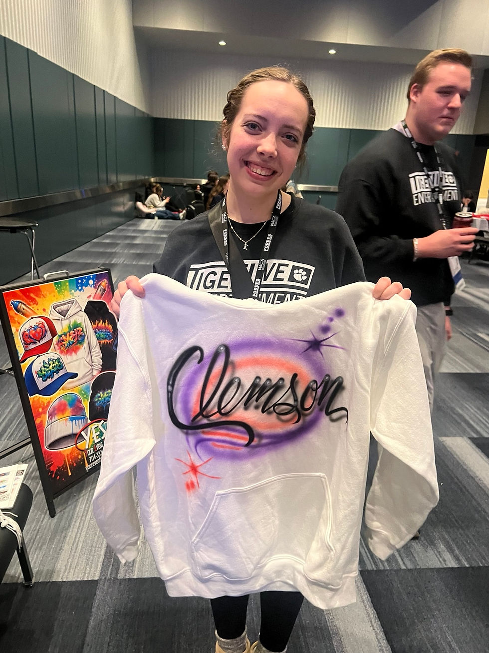 Student holding a custom name sweatshirt
