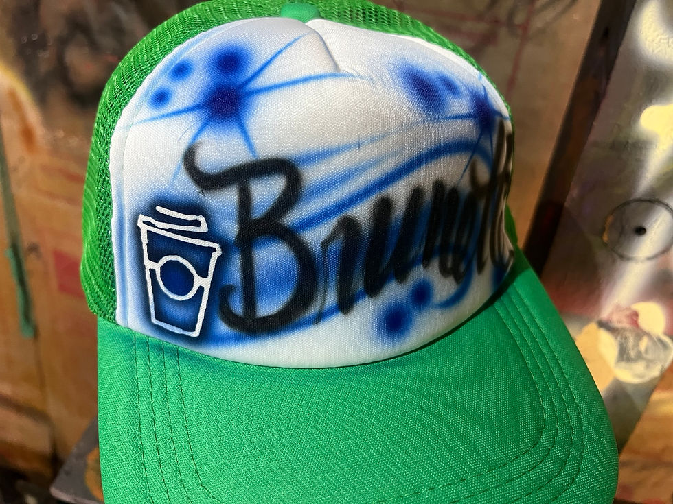 Green trucker hat with blue lettering and a coffee cup design at the 7 Brew Nashville event