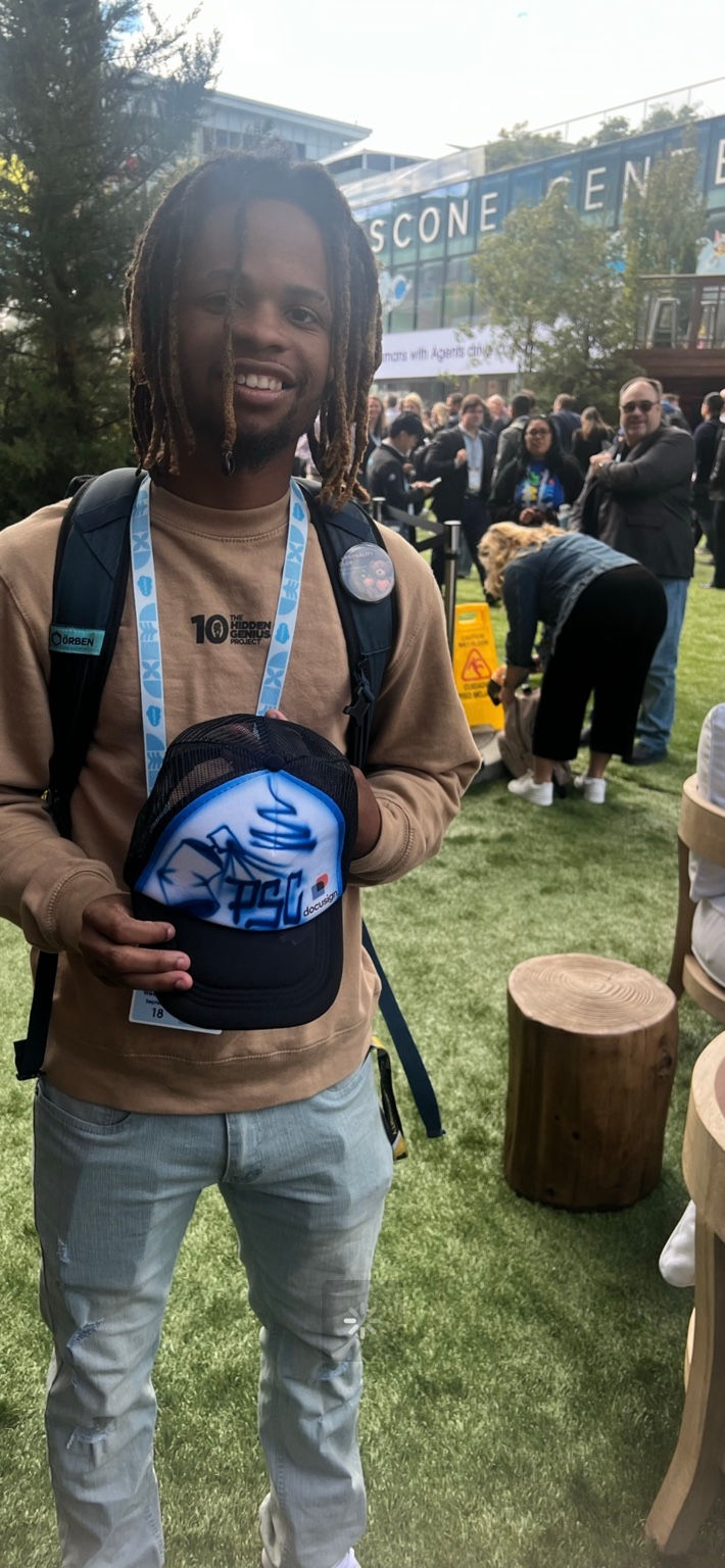Conference attendee holding a custom airbrushed DocuSign hat at Dreamforce