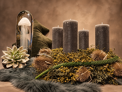 Ruhiger Adventskranz mit grauen Stumpenkerzen, Tannengrün, Moos, Sukkulenten und natürlichen Zweigen.
