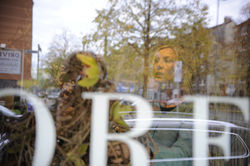 Kerstin hinter der Schaufensterscheibe im Ladenlokal von FLORES in Duisburg